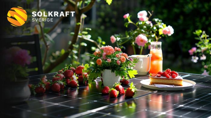 Midsommarblommor och fika med jordgubbar uppdukat på en solpanel.